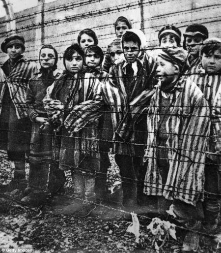 Children behind a barbed wire fence at the infamous concentration camp at Auschwitz in southern Poland